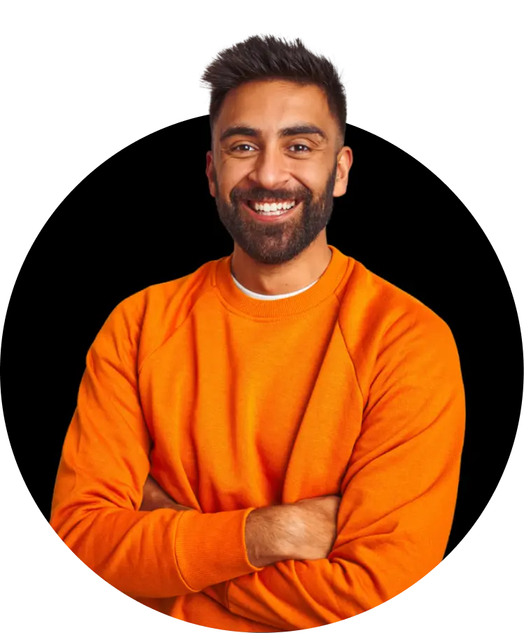 A man with medium skin tone and short dark hair, wearing an orange long-sleeve shirt. He has a friendly smile and a beard, standing with his arms crossed.